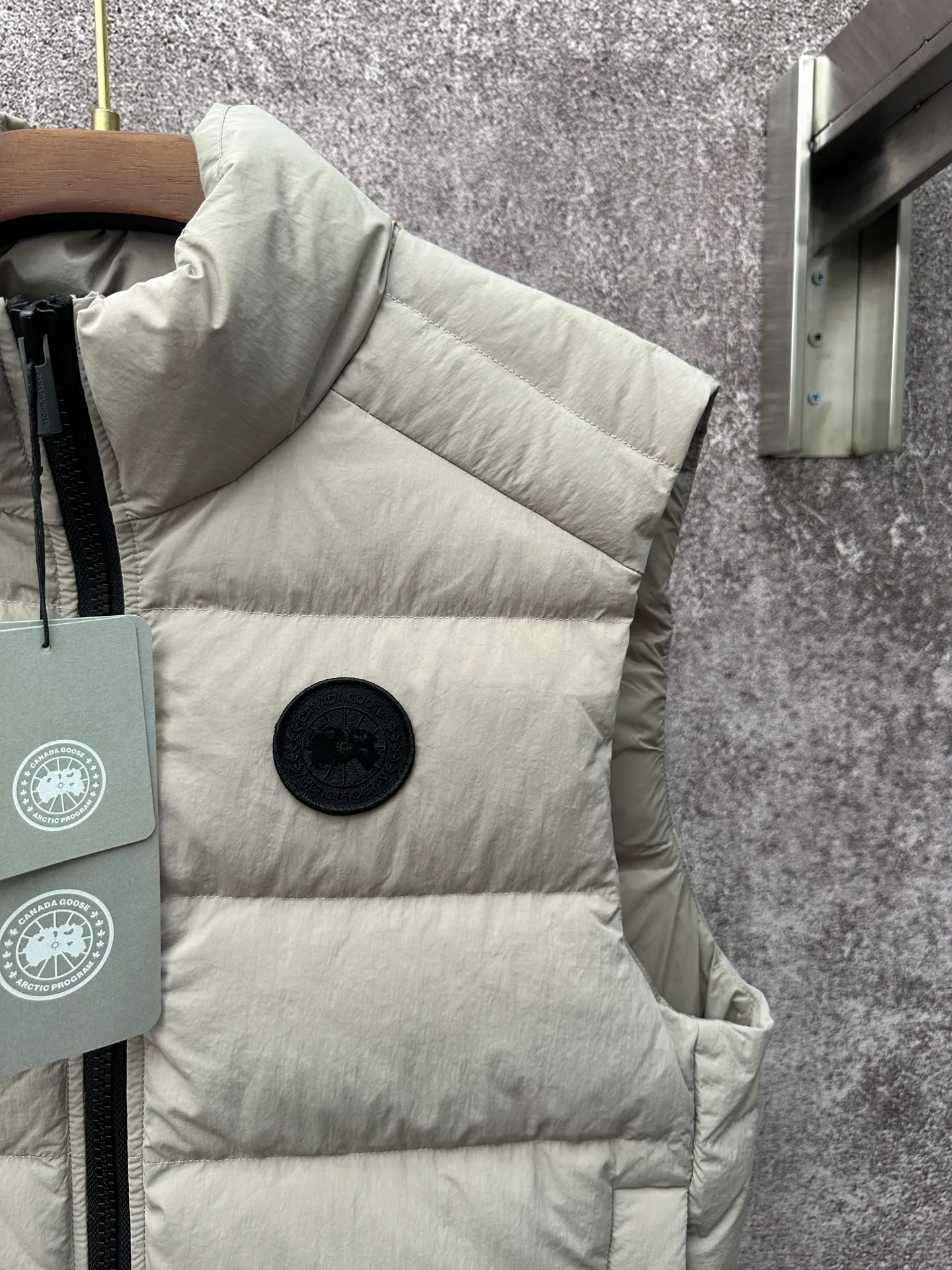 P720 Canada Goose Badge Down Vest Fabric selection: The use of high-quality protective nylon fabric not only enhances the wear resistance of the surface, but also takes into account wind resistance, ensuring excellent performance in various harsh weather conditions.  90 national standard high-quality white duck down: selected high-loft down, weighing 160g, light and warm, with excellent temperature locking performance and good resilience.  Three-dimensional quilting process: Precision thread reinforcement to prevent velvet drilling and ensure that the fluffy and resilient elasticity lasts as new.  Details: The ribbon is woven with polyester as the base, and the brand letters are decorated on the ribbon through high-precision computer embroidery. The edges of the pattern are clear, the stitches are fine and even, and multiple layers of embroidery thread are stacked to enhance the three-dimensional effect. Accessories: One-to-one customized logo, one-to-one customized zipper puller, one-to-one customized three-label SIZE: S M L XL